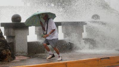 Typhoon headed to Taiwan injures dozens, with thousands evacuated