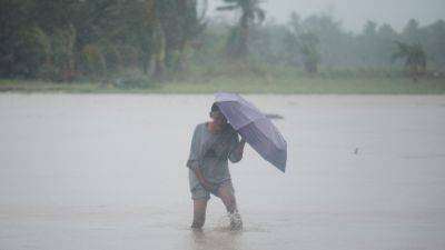 Tropical storm battering Philippines leaves at least 24 people dead in flooding and landslides