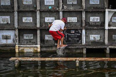 Filipinos brave crowds, flooding for All Saints' Day cemetery visits